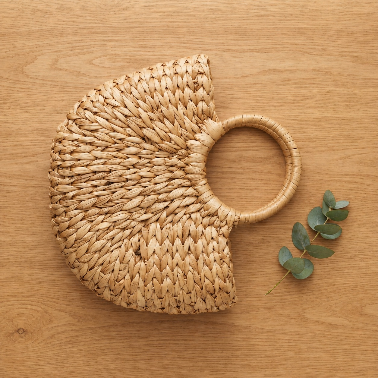 Water Hyacinth Handbag shown from above on a wooden desk
