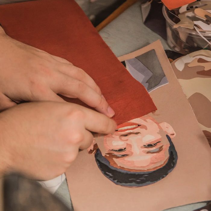 An artisan piecing together a silk patchwork portrait